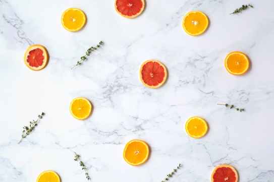 flatlay photography of sliced citrus fruits on marble surface
